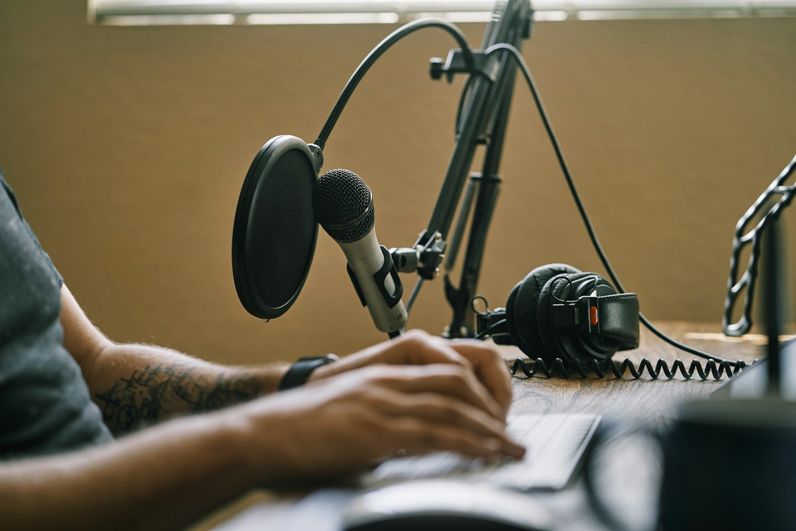 Close-up of a podcast microphone and headphones on a studio desk